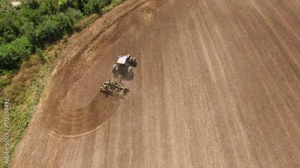 Aerial view of tractor cultivating wheat stubble field Aerial view of tractor cultivating wheat stubble field