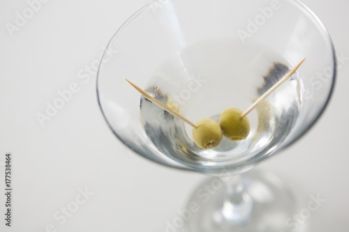 Cocktail martini with olives on table