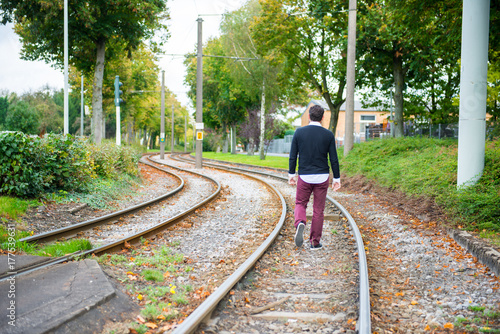 man is walking on the railway