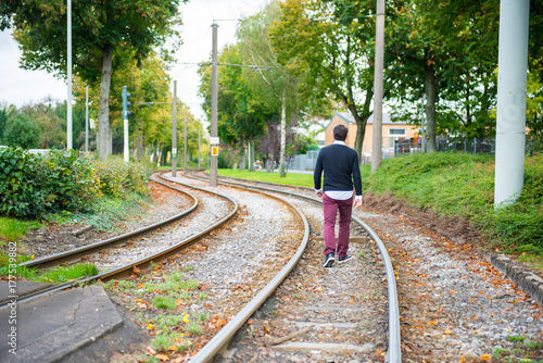 man is walking on the railway