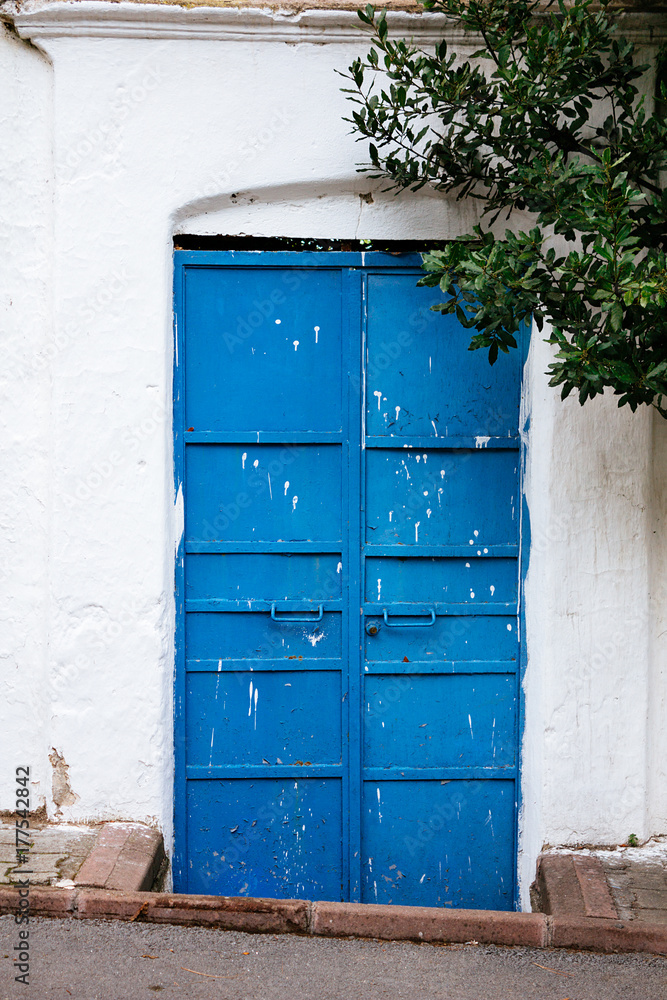 Blue door in white wall vertical Blue door in white wall vertical