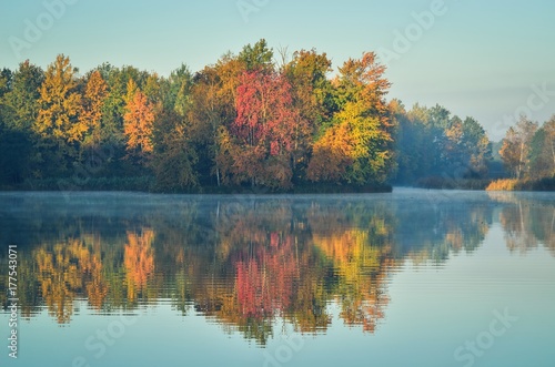 Beautiful autumn landscape. Colorful trees by the lake.
