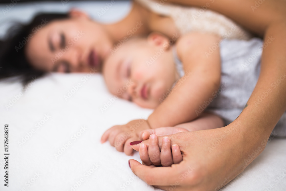 Beautiful mother and cute little baby boy sleeping together on bed. Beautiful mother and cute little baby boy sleeping together on bed.