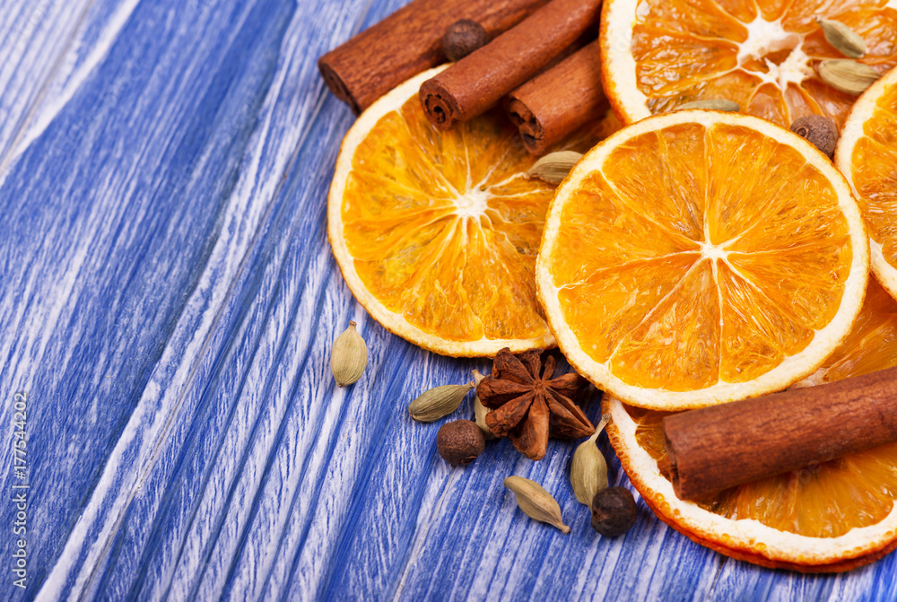 Φωτογραφία Dry slices of orange, cinnamon, allspice and cardamom on a blue wooden backgroun