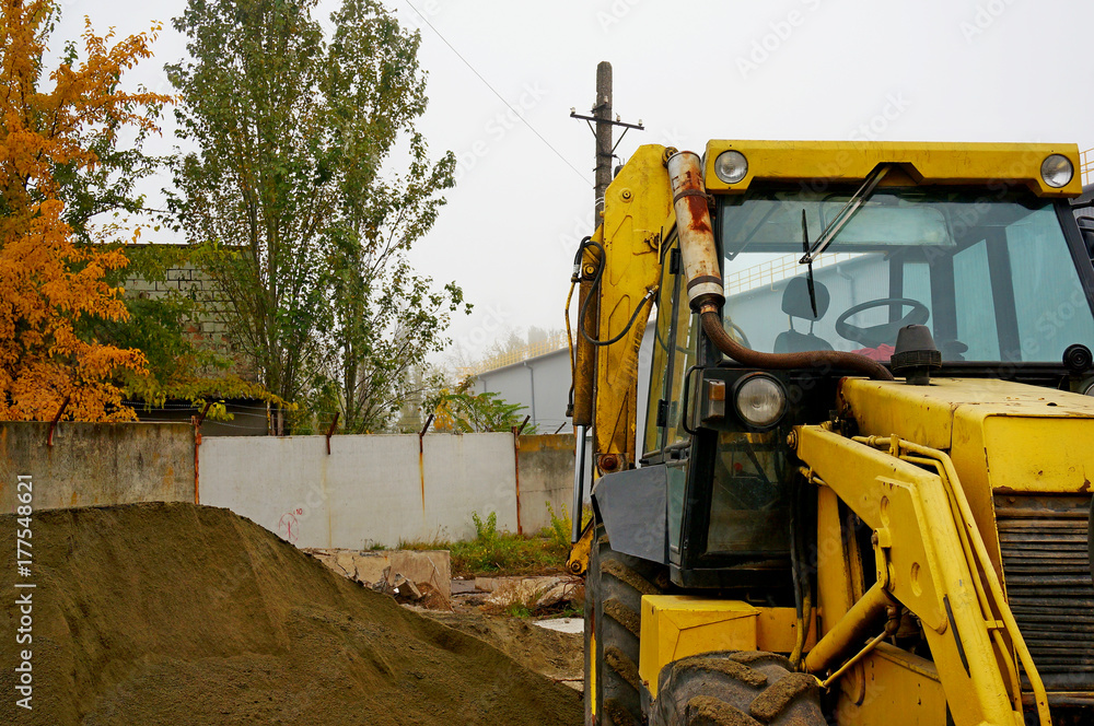 The concept of agronomy, a yellow tractor with a bucket demonstrates work The concept of agronomy, a yellow tractor with a bucket demonstrates work