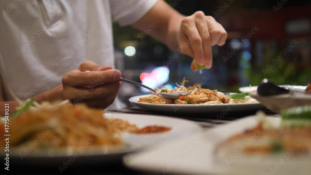 Man Squeezing Lime Juice on Traditional Pad Thai Noodle in Restaurant. 4K, Thailand. Man Squeezing Lime Juice on Traditional Pad Thai Noodle in Restaurant. 4K, Thailand.
