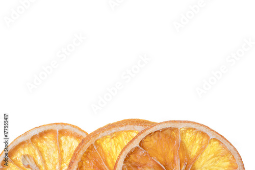 Three slices of dried orange placed on bottom edge on white background photo