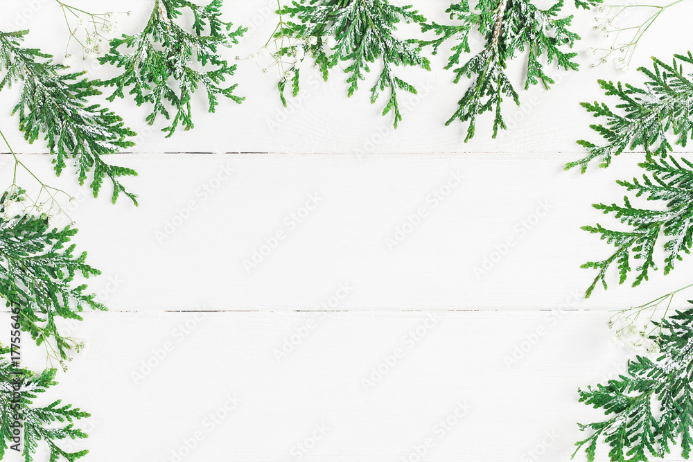 Christmas frame made of thuja branches and gypsophila flowers on white wooden background. Christmas, winter, new year concept. Flat lay, top view, copy space Christmas frame made of thuja branches and gypsophila flowers on white wooden background. Christmas, winter, new year concept. Flat lay, top view, copy space