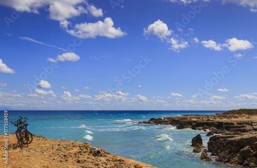 The most beautiful coast of Apulia  Torre Sant  Andrea  Otranto   ITALY  Lecce .Typical coastline of Salento  a pair of bikes for excursions. Seascape with cliffs  rocky arch and sea stacks.