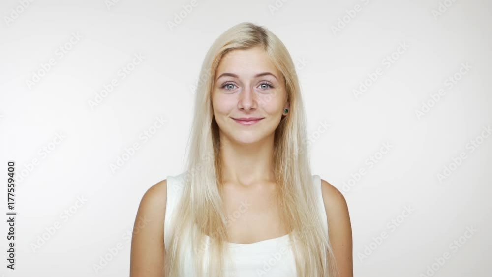 caucasian woman with long blond hair laughing out loud covering her mouth with hands giggling over white background slowmotion. Concept of emotions caucasian woman with long blond hair laughing out loud covering her mouth with hands giggling over white background slowmotion. Concept of emotions