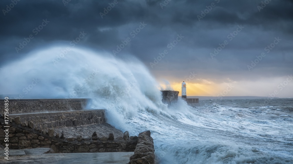 Fototapeta premium Force of nature Colosal waves batter a lighthouse as it suffers hits twice in a week when hurricane Storm Brian lands on the Porthcawl coast of South Wales, UK.