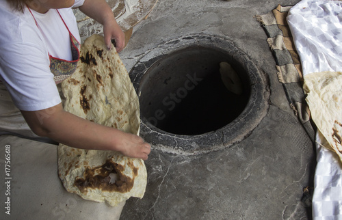 Baking traditional lavash in the tandoor photo