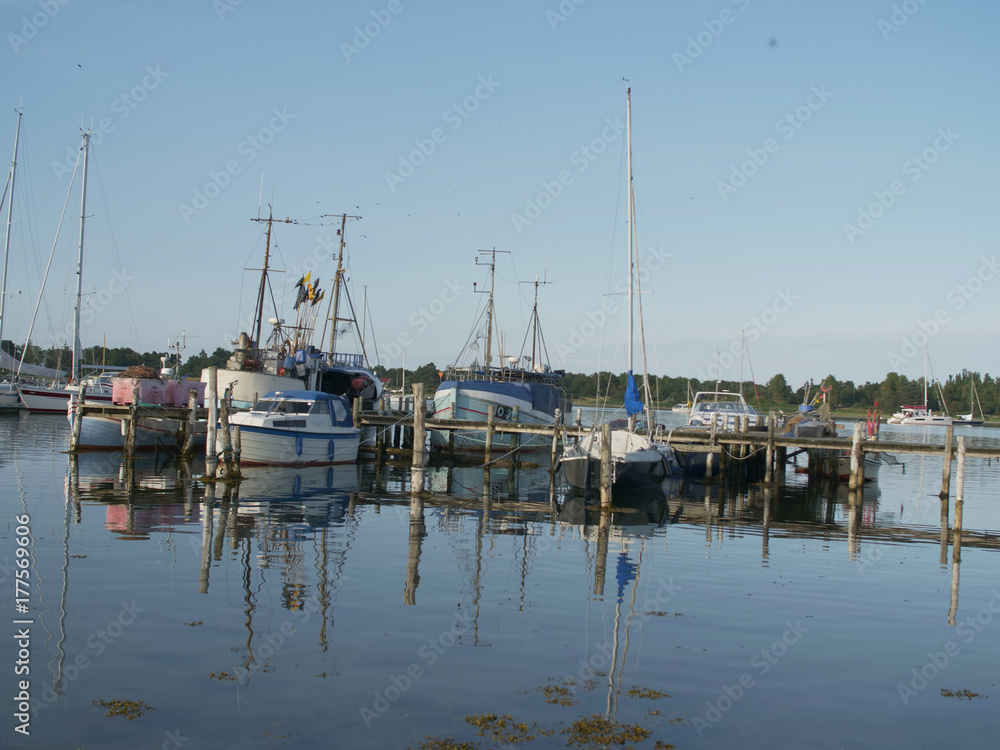 wooden pier, with sailboats and dinghys with blue sky in the summer wooden pier, with sailboats and dinghys with blue sky in the summer