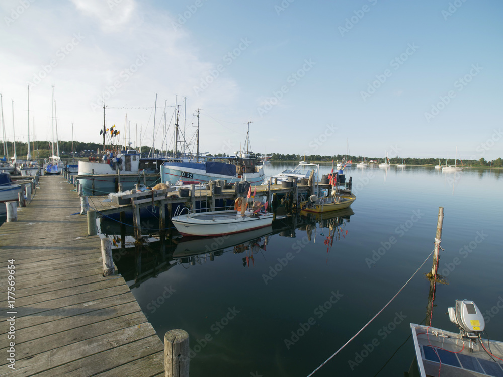 wooden pier, with sailboats and dinghys with blue sky in the summer wooden pier, with sailboats and dinghys with blue sky in the summer
