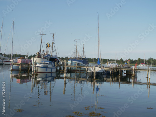 wooden pier  with sailboats and dinghys with blue sky in the summer