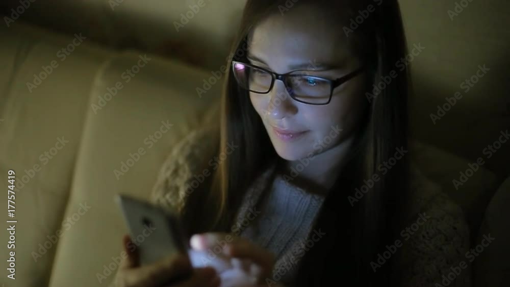 Beautiful woman using smartphone at home late night, very surprised, emotions Beautiful woman using smartphone at home late night, very surprised, emotions