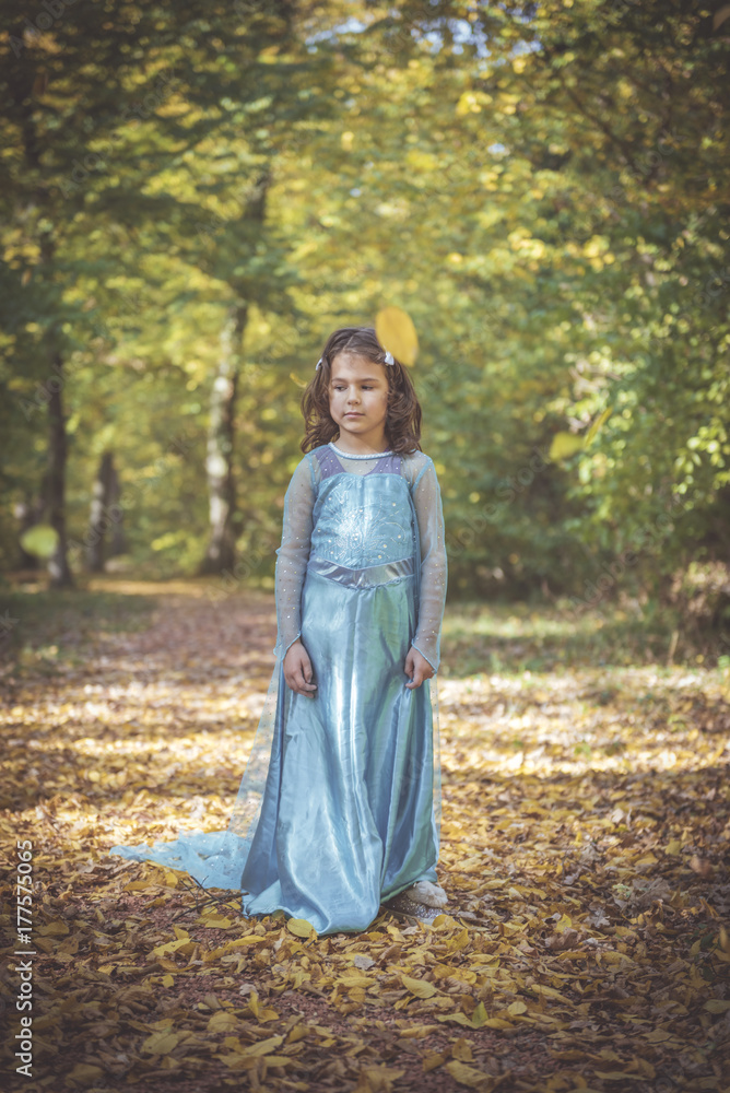 Little girl in blue dress posing in the woods,selective focus Little girl in blue dress posing in the woods,selective focus