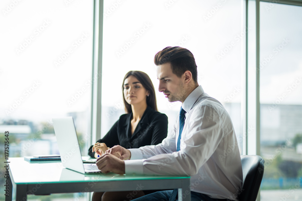 Young couple working together on a laptop in the office. Teamwork concepts. Young couple working together on a laptop in the office. Teamwork concepts.