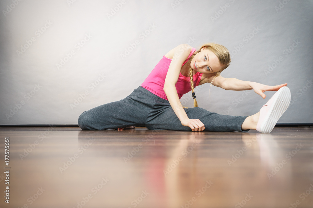 Woman in sportswear stretching legs