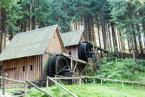 Western style pioneer frontier water mill wheel wooden building in the forest
