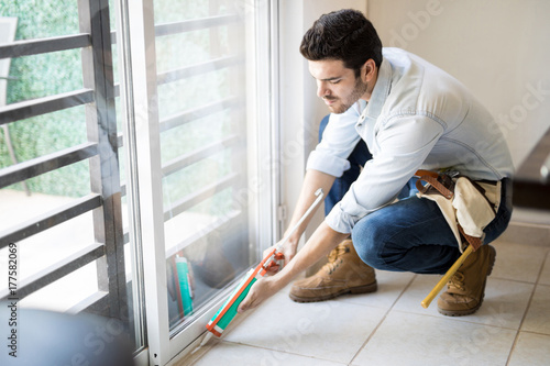 Handyman sealing a window frame photo