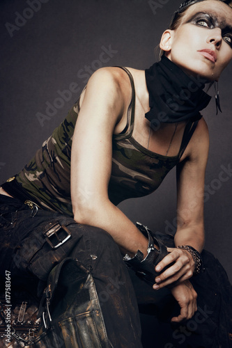 Young woman in brutal futuristic clothes on black background © EVGENY FREEONE