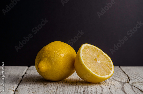 Lemons on white rustic table in front of the dark background