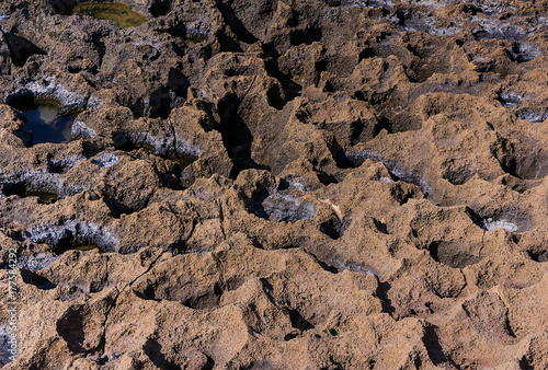 Volcanic background texture rocky coast winded with craters with sea water and the edge of salt