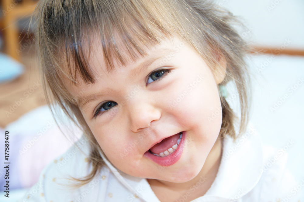 Cute smiling little girl portrait lying on white blanket Stock Photo ...