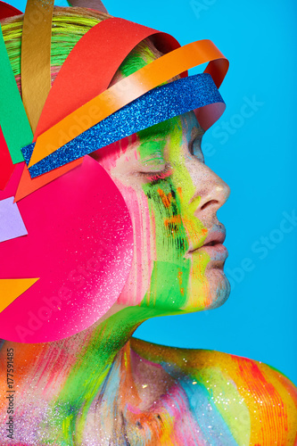 Model with colorful abstract makeup in multicolored helmet