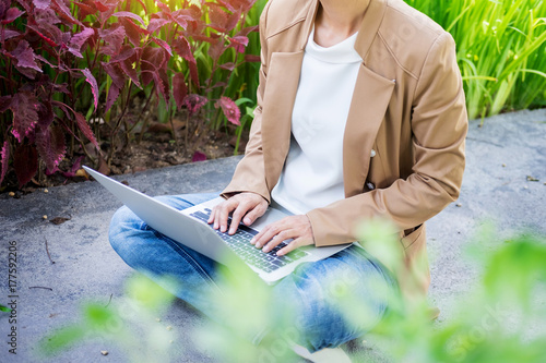 business woman hand using laptop on table in garden.