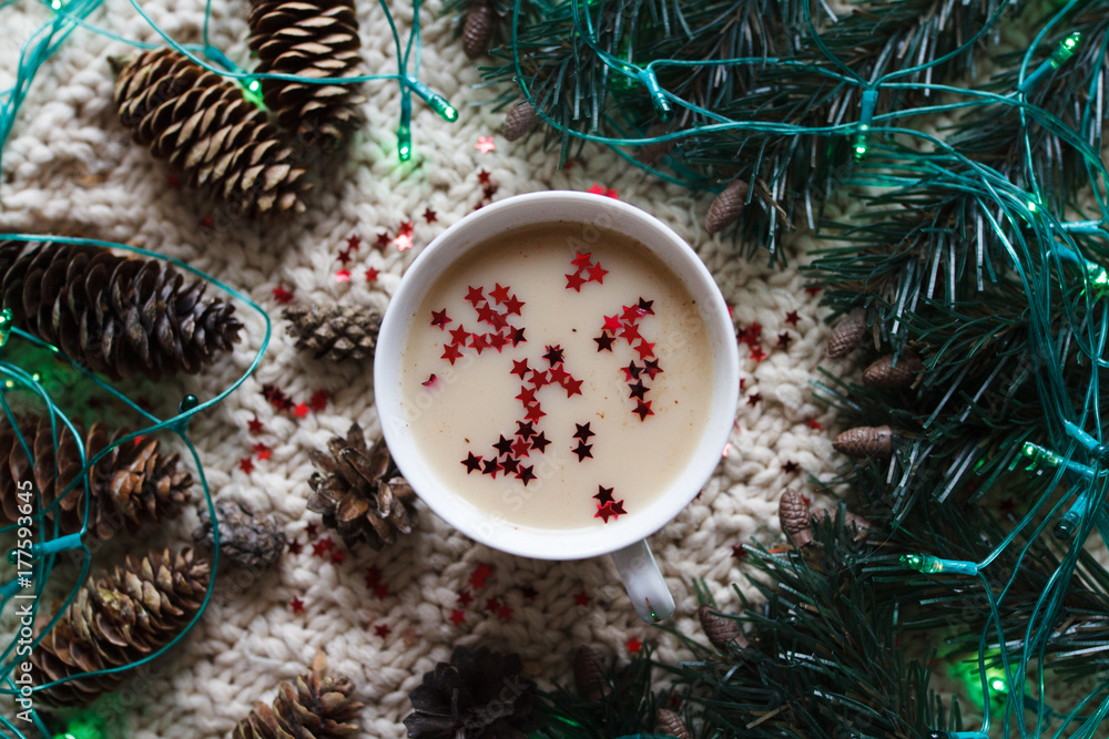 A cup of coffee with Christmas decorations, fir branches, pine cones and garland A cup of coffee with Christmas decorations, fir branches, pine cones and garland