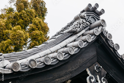 Close up detail roof of Edo period architecture style with leaves less tree in Noboribetsu Date JIdaimura Historic Village at Hokkaido, Japan. photo