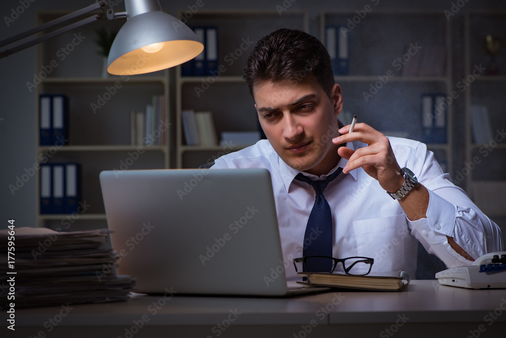 Businessman under stress smoking in office Businessman under stress smoking in office