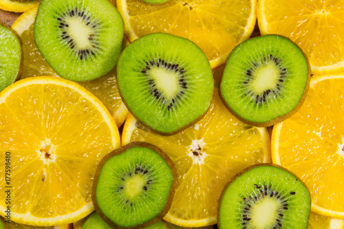 Sliced kiwi fruits and oranges for background