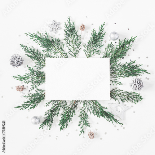 Christmas composition. Paper blank  pine tree branches  christmas silver decorations on white background. Flat lay  top view  copy space  square