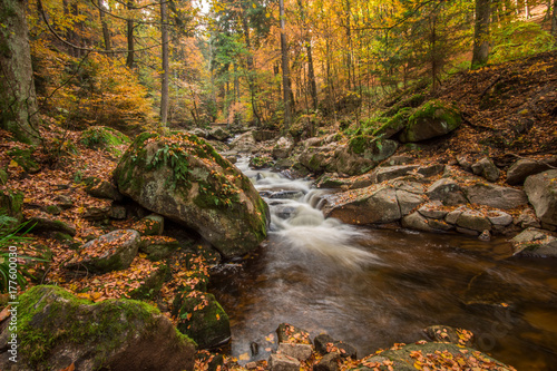 Mountain stream with waterfall in an autumn forest. time exposure