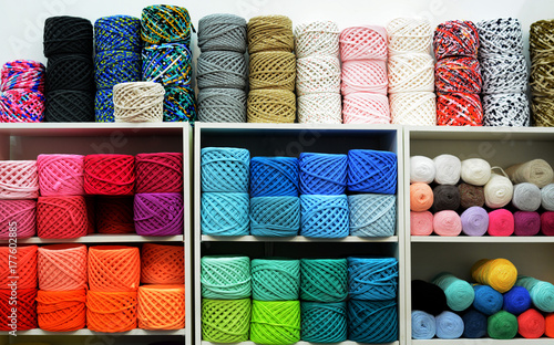 Colorful Balls Of Wool On Shelves. Variety of knitting yarns. Different Yarn balls in multiple colors. Yarn Storage.