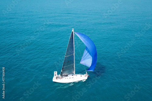 Small yacht with large open blue sail