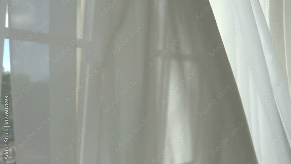 Curtains transparent to the world through the window. The curtain blown by a gentle wind. Window to the world of light and happiness. Curtains transparent to the world through the window. The curtain blown by a gentle wind. Window to the world of light and happiness.