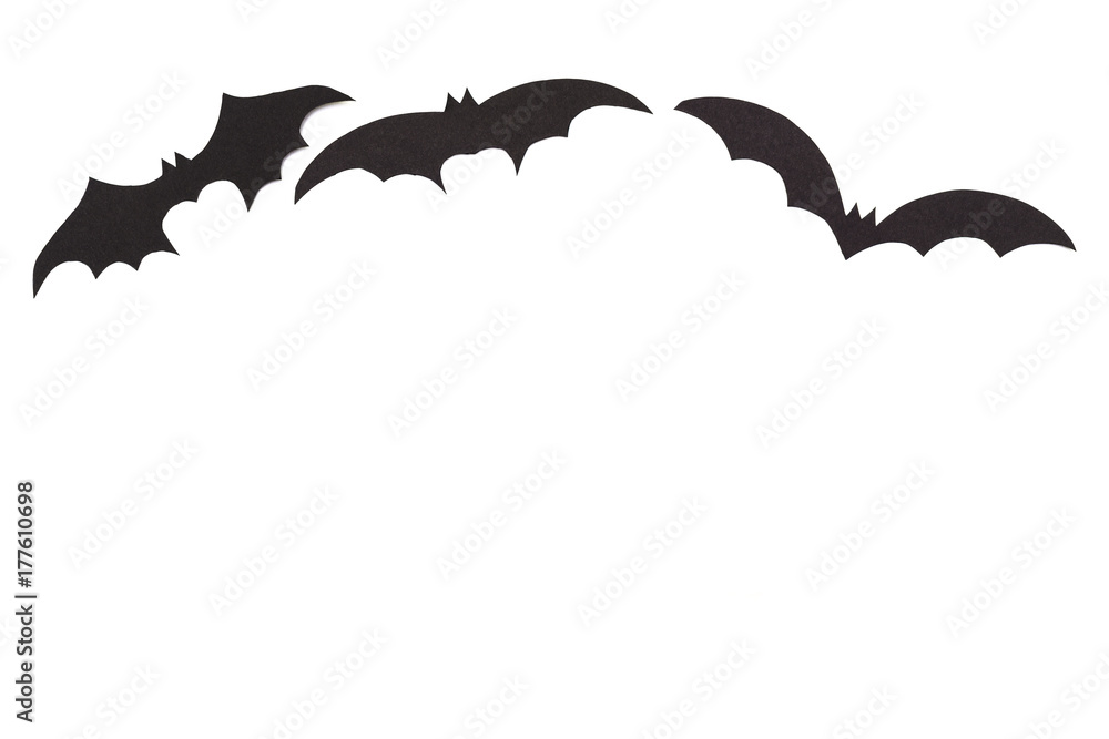 Silhouettes of volatile bats carved out of black paper are isolated on white Silhouettes of volatile bats carved out of black paper are isolated on white