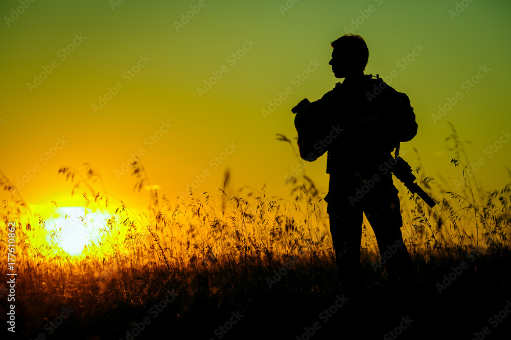 military soldier with weapons at sunset. shot, holding gun, colorful sky. military concept.