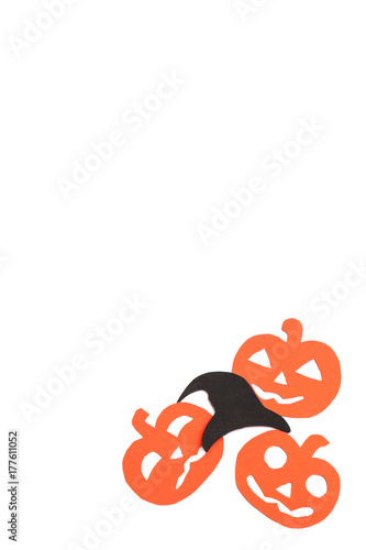Silhouettes of orange pumpkins and black hat carved out of black paper are isolated on white