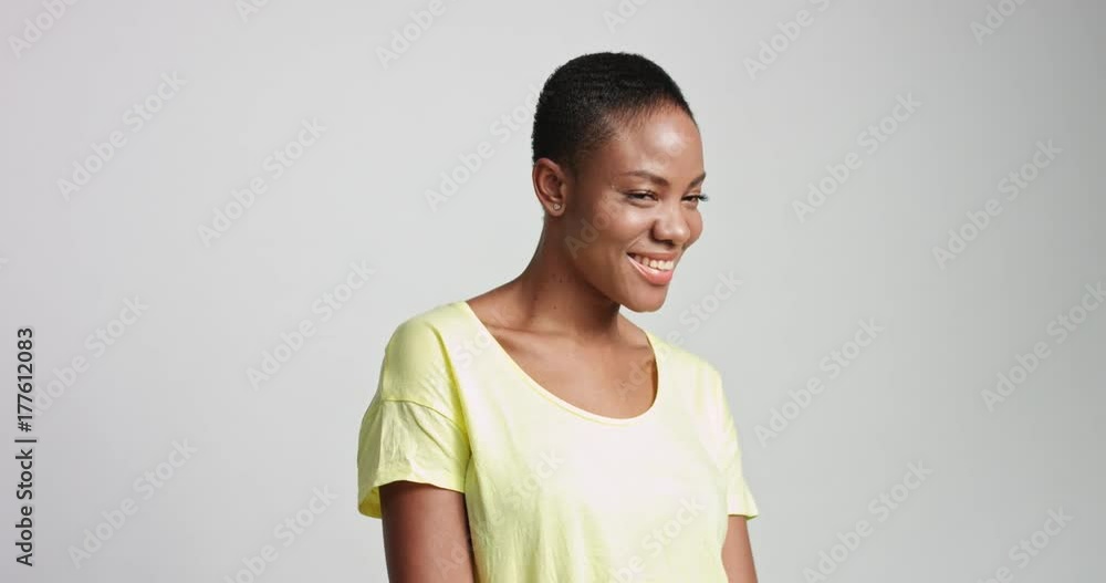 Attractive fit African American female model wearing a casual light blue short sleeve shirt on white background and smiling Attractive fit African American female model wearing a casual light blue short sleeve shirt on white background and smiling