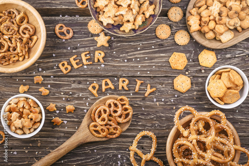 Inscription beer and party composed of crackers on a wooden board. Salty snacks. Pretzels, crackers.