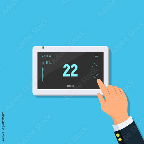 Modern digital touchscreen thermostat. Close-up of person hand with temperature controller. Concept air conditioning and smart home.