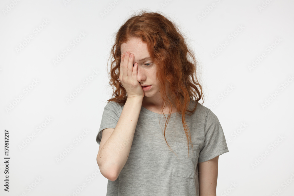 Disappointed stressed out redhead female making facepalm gesture with hand. Face palm concept Disappointed stressed out redhead female making facepalm gesture with hand. Face palm concept