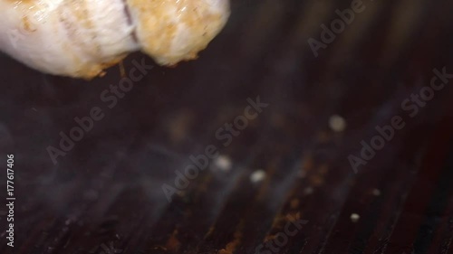 Tongs Holding Grilled Pork Ribs. Hot Flaming BBQ Grill on the Background photo