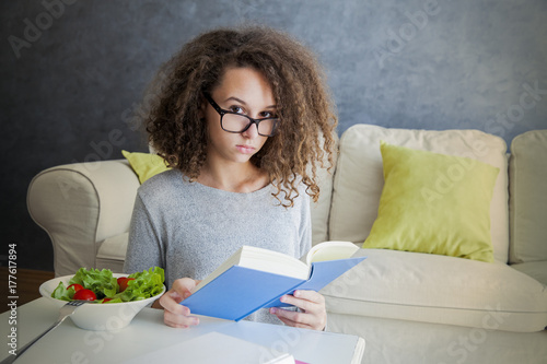 Curly hair teen girl readin...