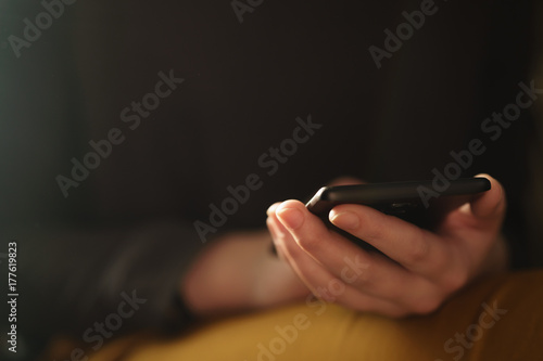 teen girl using smartphone backlit by window light